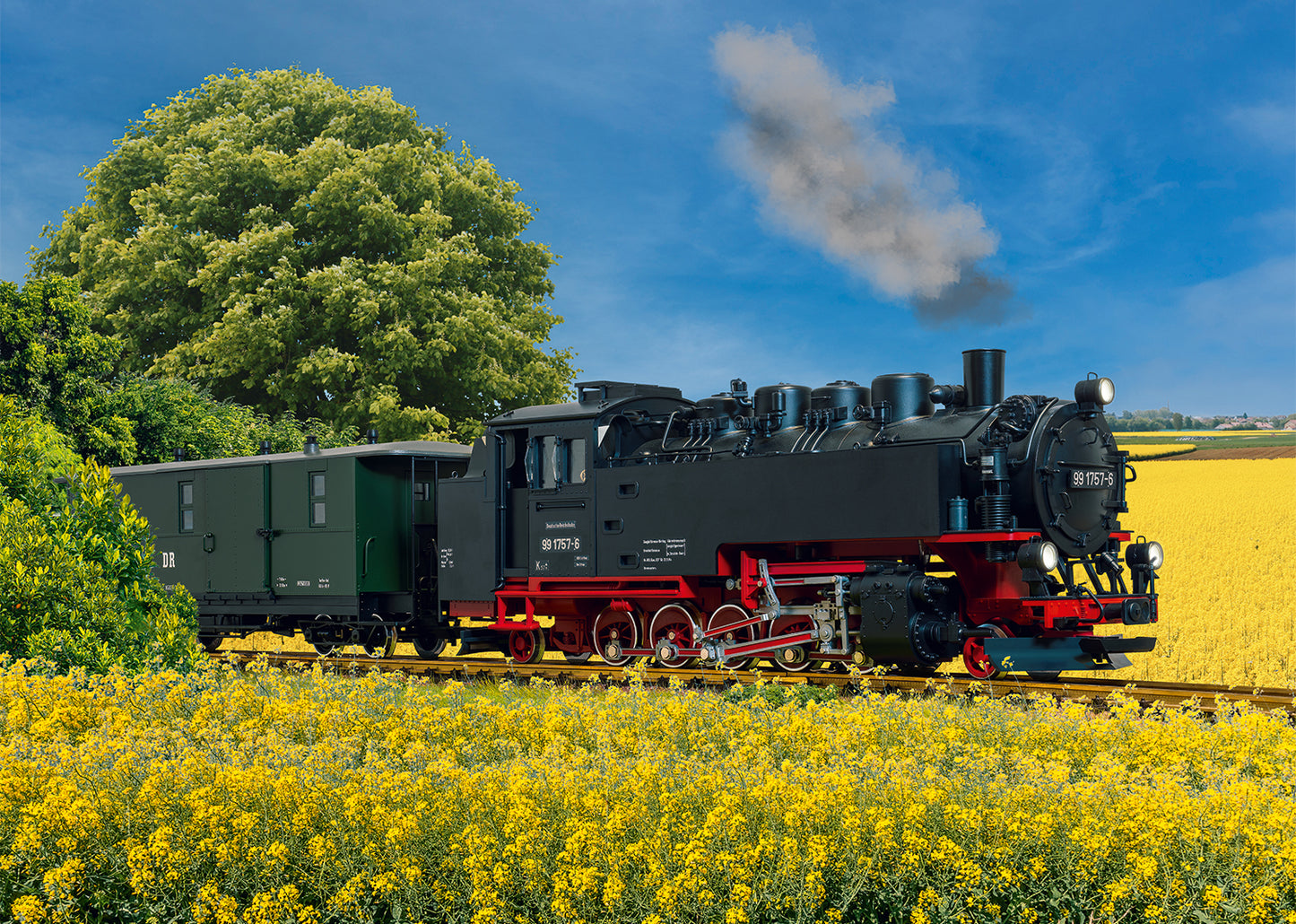 LGB 21484 - DR Steam Locomotive, Road Number 99 1757-6. Steam locomotive on tracks with yellow flowers and green trees in the background